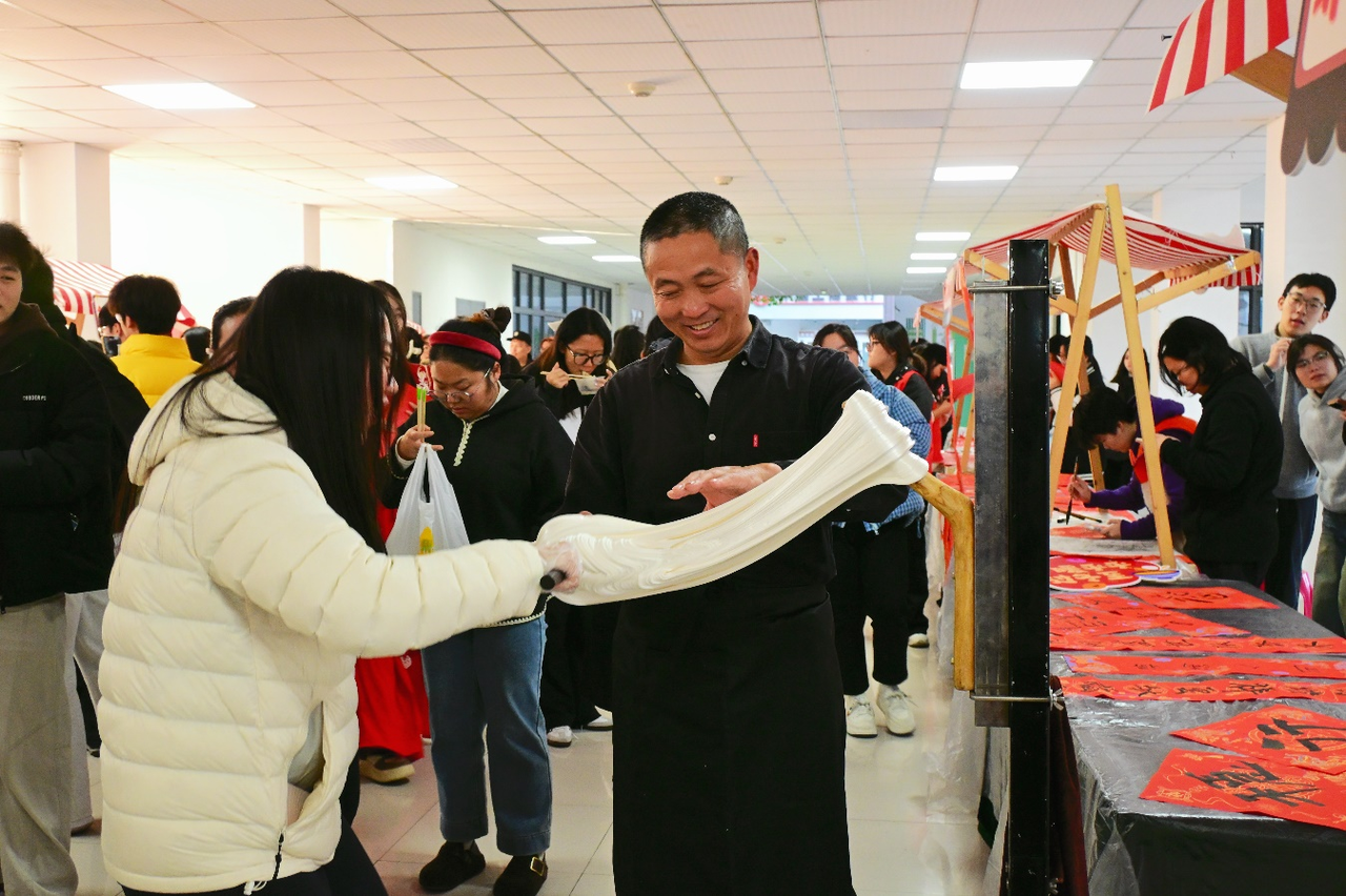 学生上手体验非遗“扯白糖”.png