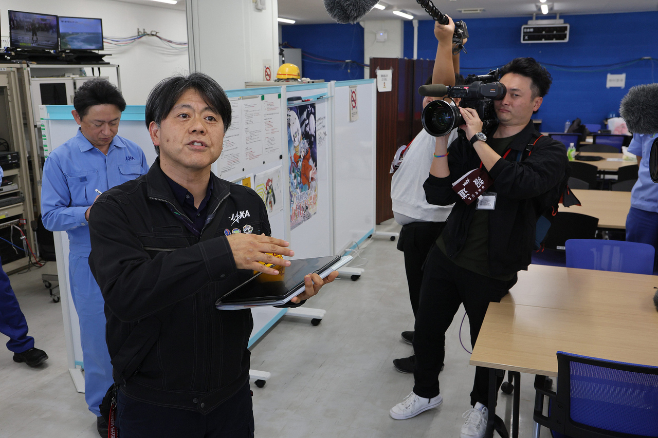 12月22日,日本鹿儿岛县南种子町,日本宇宙航空研究开发机构(JAXA)发言人(左)在种子岛宇宙中心解释.jpg