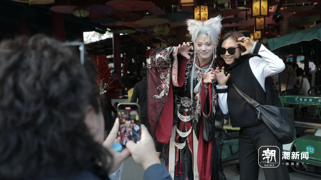 “小狐狸”和游客摆拍专属造型。杜雪梅/摄